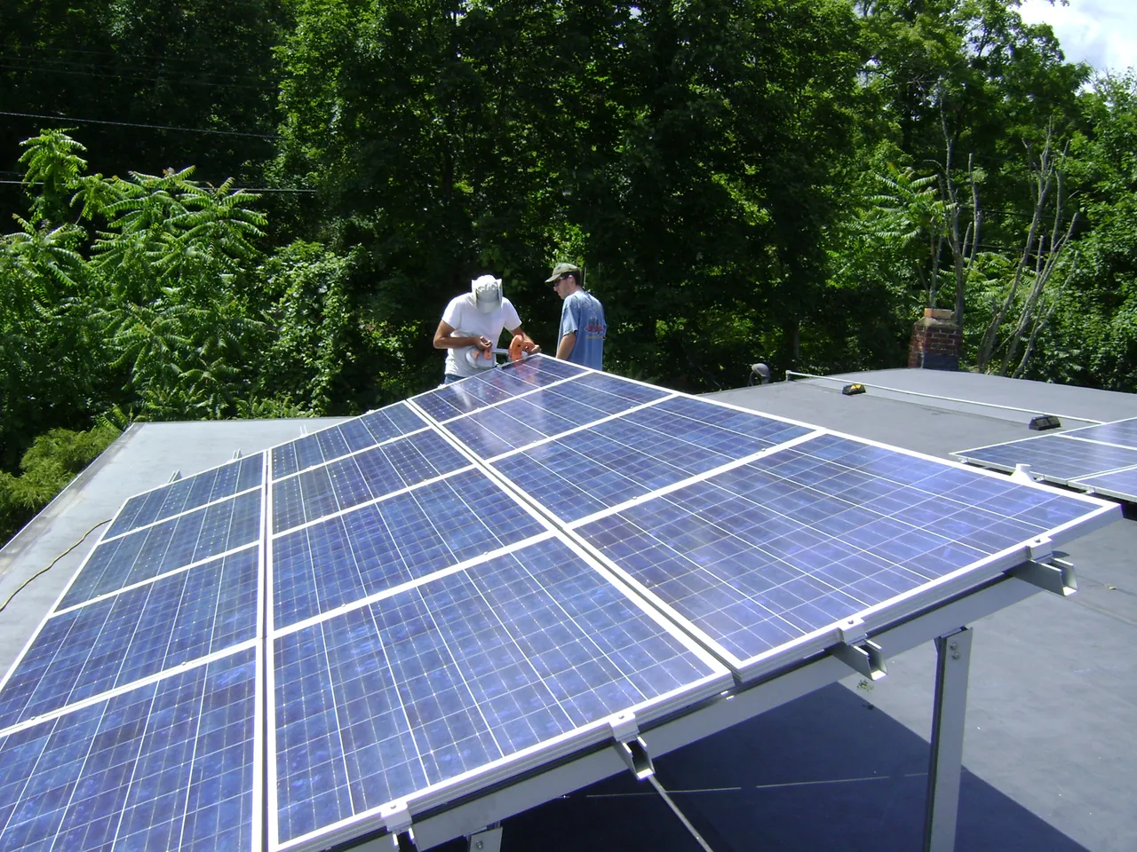 Dos personas junto a una instalación fotovoltaica en cubierta
