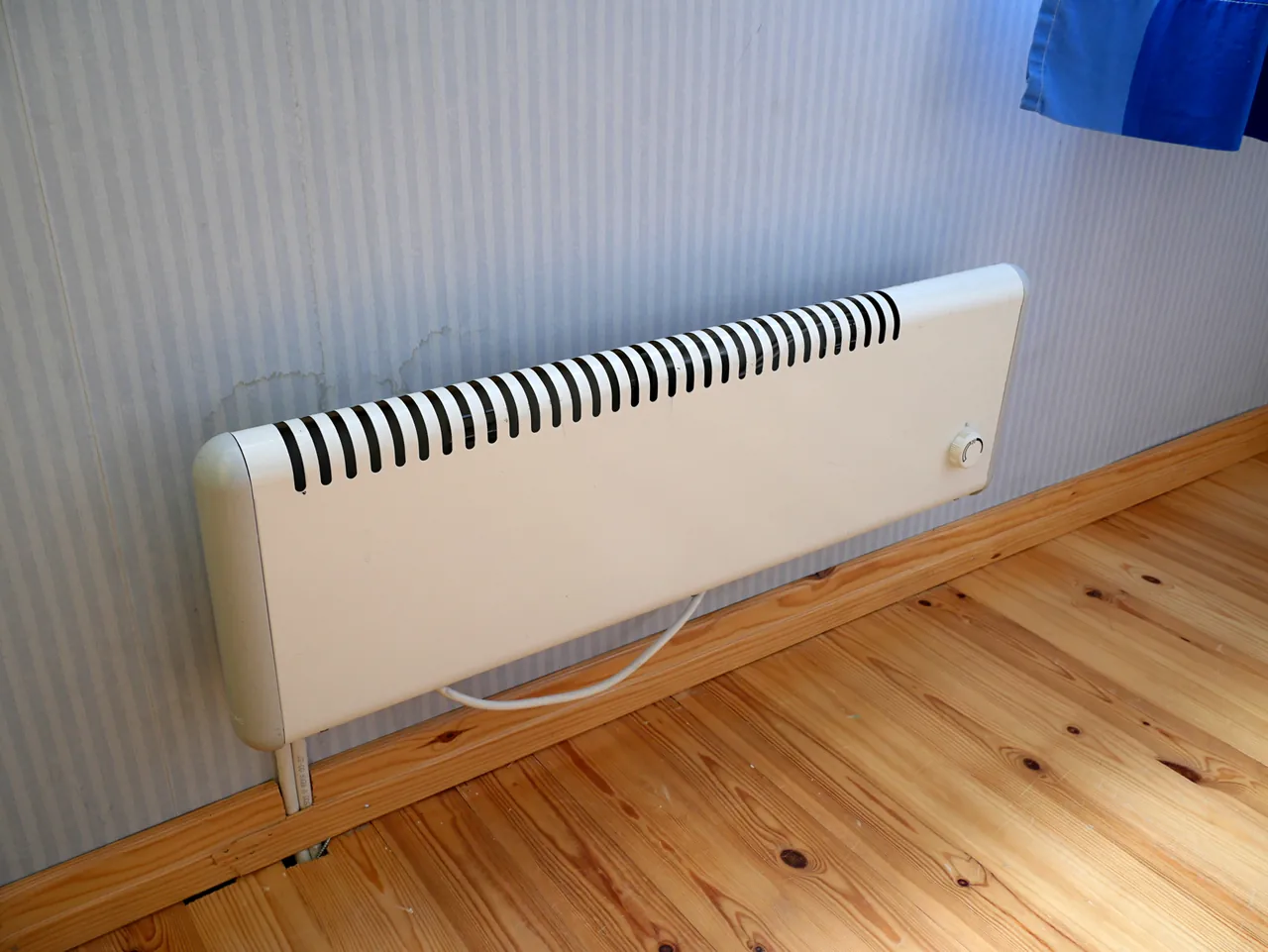 Radiador eléctrico de pared sobre un suelo de madera